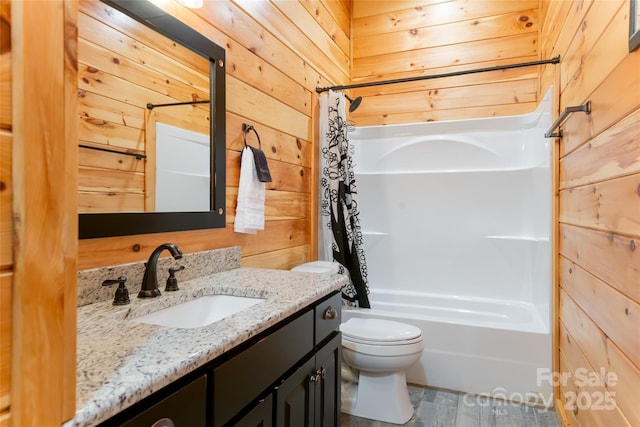 full bath with shower / bathtub combination with curtain, wooden walls, vanity, and toilet