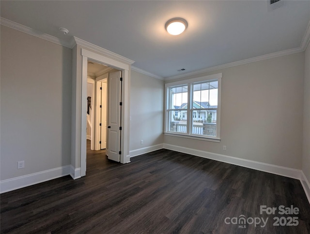 empty room with visible vents, baseboards, ornamental molding, and dark wood finished floors