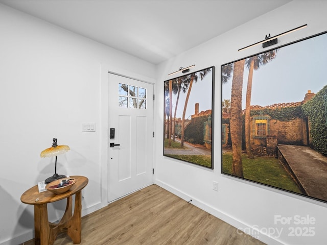 foyer entrance featuring light wood-type flooring and baseboards