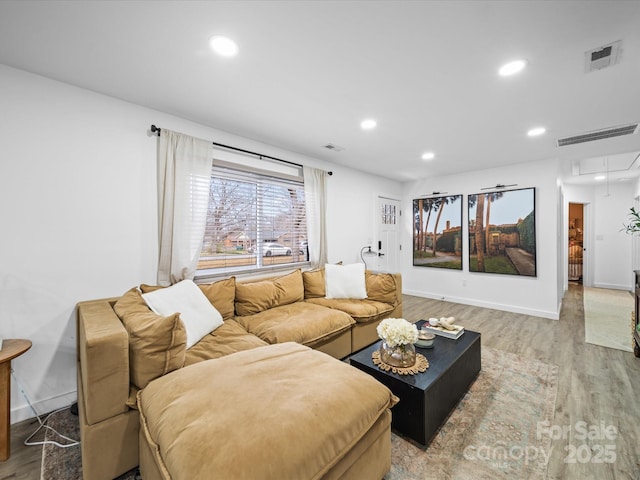 living area featuring visible vents, recessed lighting, attic access, and light wood-type flooring