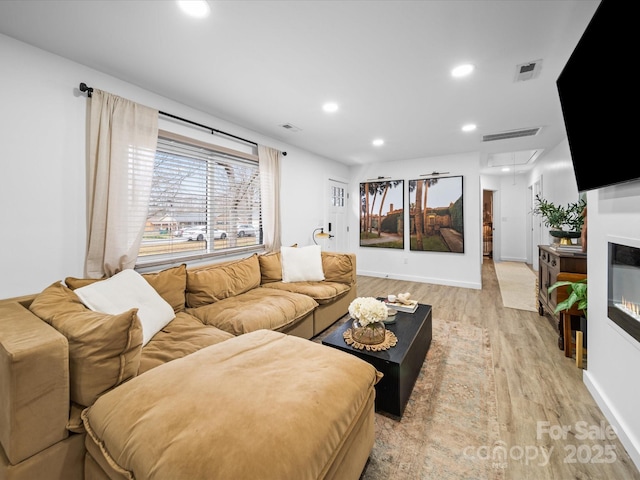 living area featuring visible vents, recessed lighting, attic access, and light wood-style floors