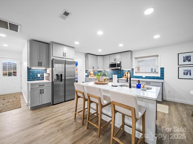 kitchen featuring stainless steel appliances, visible vents, and light countertops