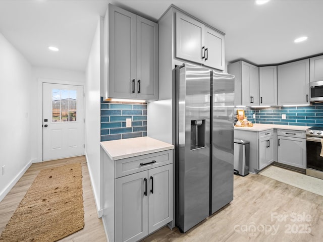 kitchen with light countertops, light wood-style floors, gray cabinets, and stainless steel appliances