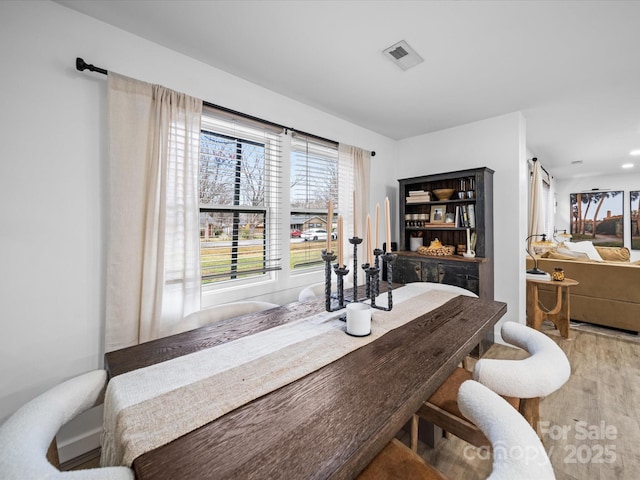 dining space featuring visible vents and wood finished floors