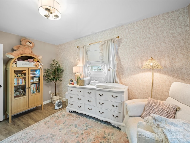 sitting room with wallpapered walls, baseboards, and wood finished floors