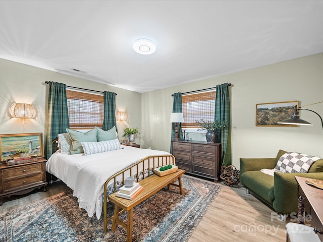 bedroom featuring visible vents and wood finished floors