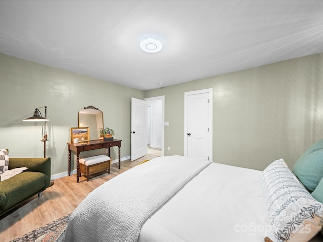 bedroom with baseboards and wood finished floors