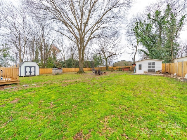 view of yard with a storage unit, an outbuilding, and a fenced backyard