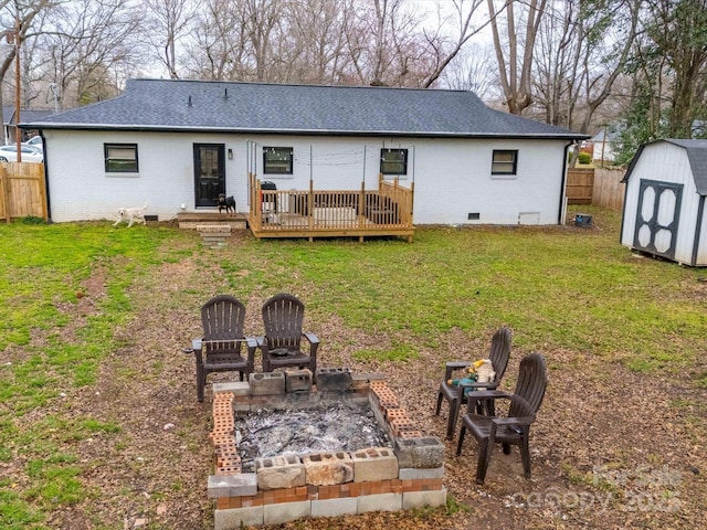 back of house with crawl space, a shed, an outdoor fire pit, and a deck