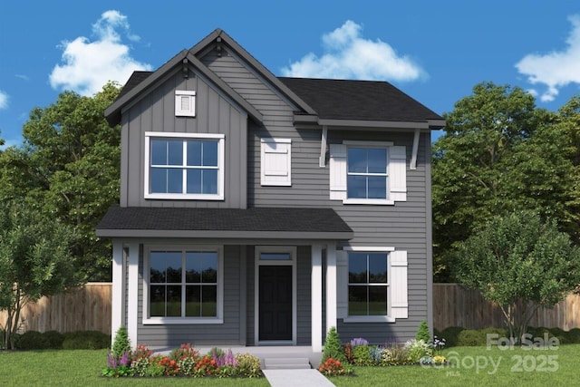 view of front facade featuring board and batten siding, a shingled roof, a front lawn, and fence