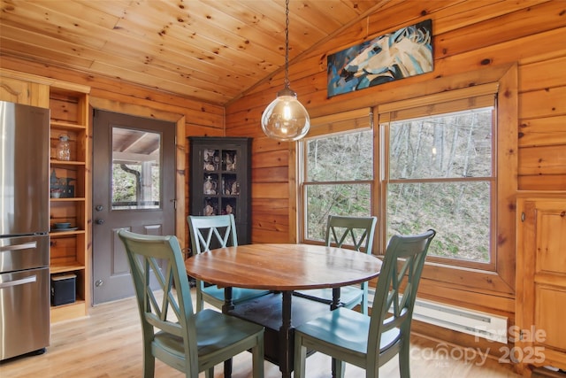 dining room featuring a wealth of natural light, wooden ceiling, wooden walls, and lofted ceiling