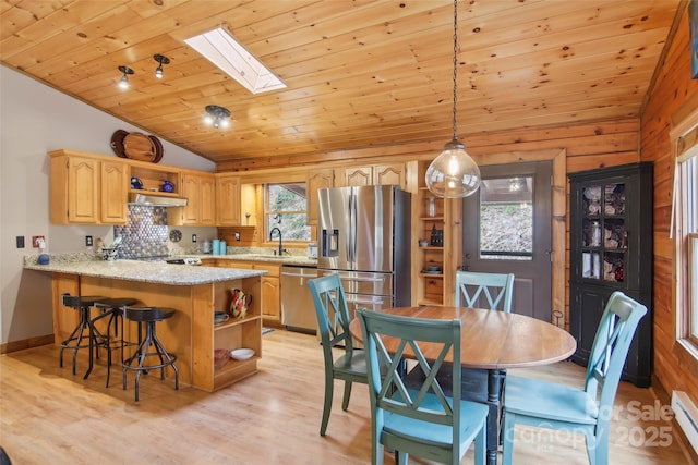 dining room featuring vaulted ceiling with skylight, wood ceiling, light wood-type flooring, and a baseboard radiator