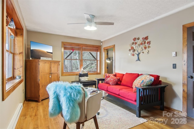 living room with light wood-style flooring, a ceiling fan, a textured ceiling, a baseboard radiator, and baseboards