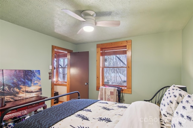 bedroom with a textured ceiling and ceiling fan