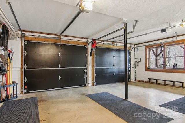 garage featuring concrete block wall and a garage door opener