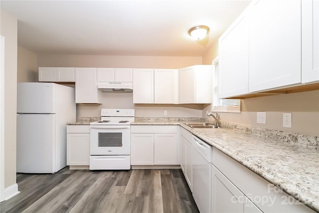 kitchen with under cabinet range hood, light wood-style flooring, white cabinets, white appliances, and a sink