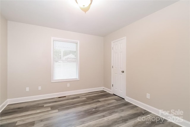 empty room with wood finished floors and baseboards