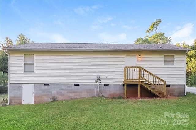 rear view of house with crawl space and a lawn