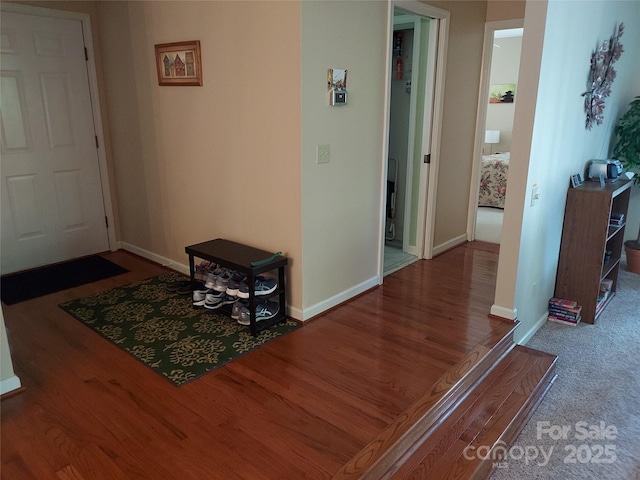 hallway with baseboards and wood finished floors