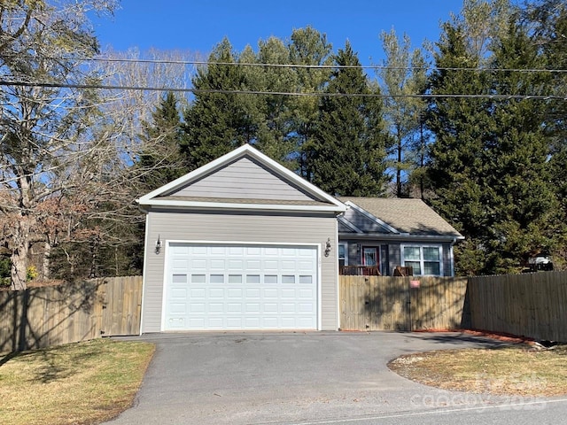 ranch-style house with aphalt driveway, a garage, and fence