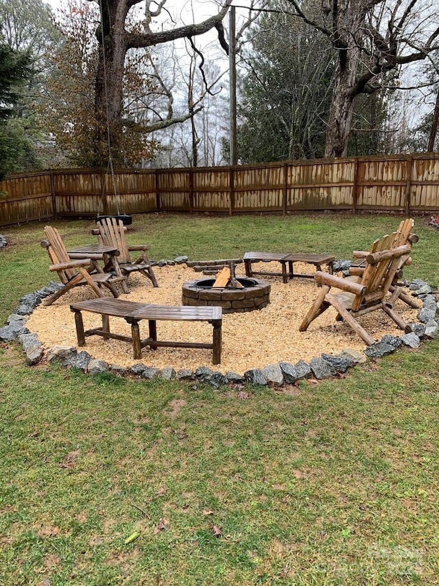 view of yard with a fire pit and a fenced backyard