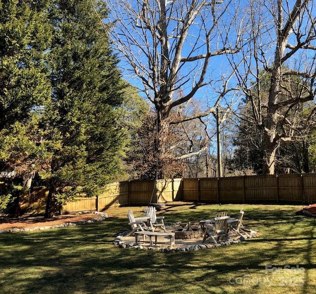 view of yard featuring a fire pit and a fenced backyard