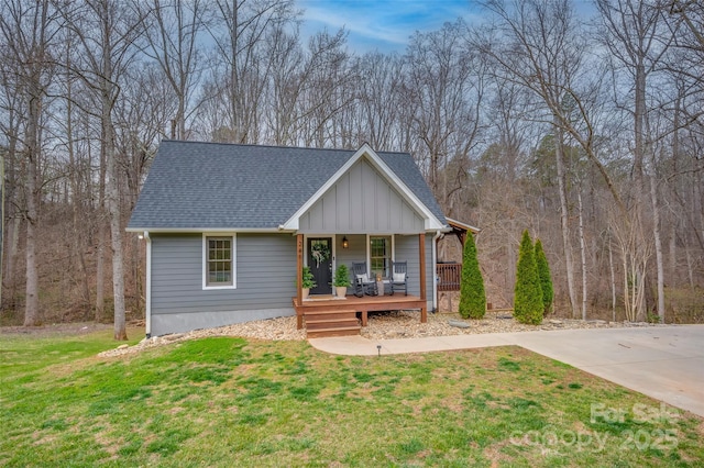 view of front of home featuring a porch, a front lawn, board and batten siding, and roof with shingles