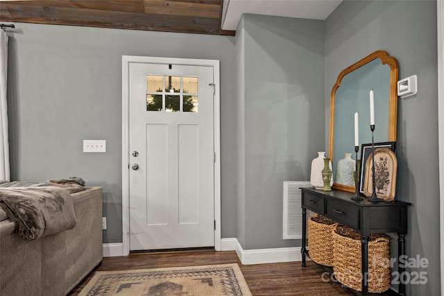 foyer featuring wood finished floors, visible vents, and baseboards