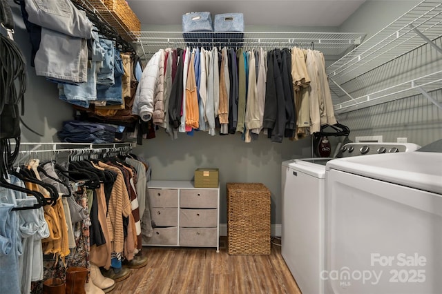 walk in closet with independent washer and dryer and wood finished floors