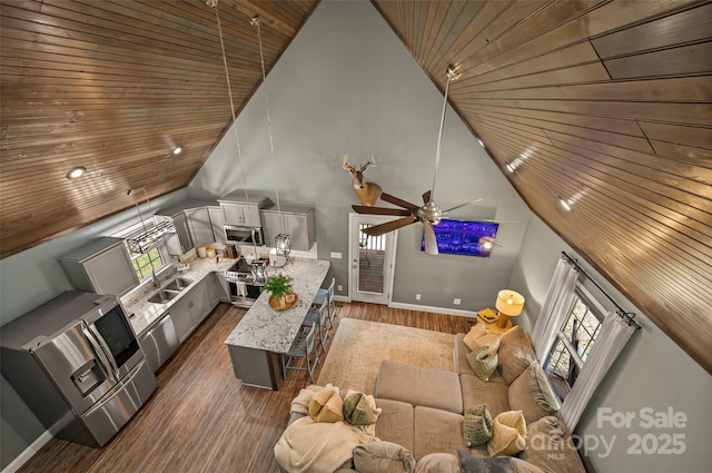 unfurnished living room with ceiling fan, wooden ceiling, wood finished floors, high vaulted ceiling, and a sink