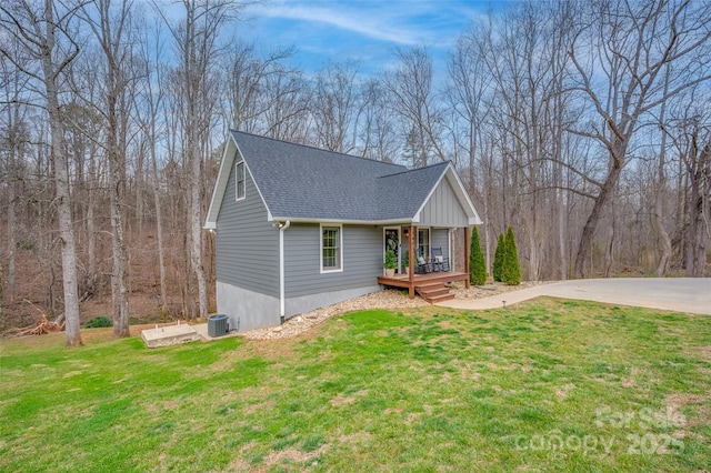 view of front of house featuring a porch, a front lawn, and roof with shingles