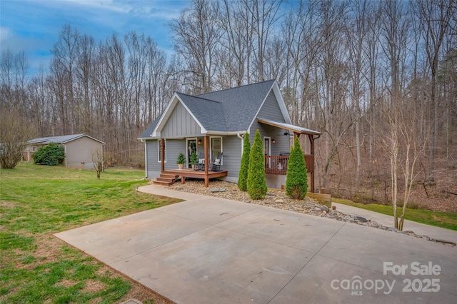 view of home's exterior featuring covered porch, a shingled roof, and a yard