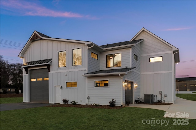 view of front of home featuring central AC unit, driveway, a standing seam roof, a yard, and board and batten siding