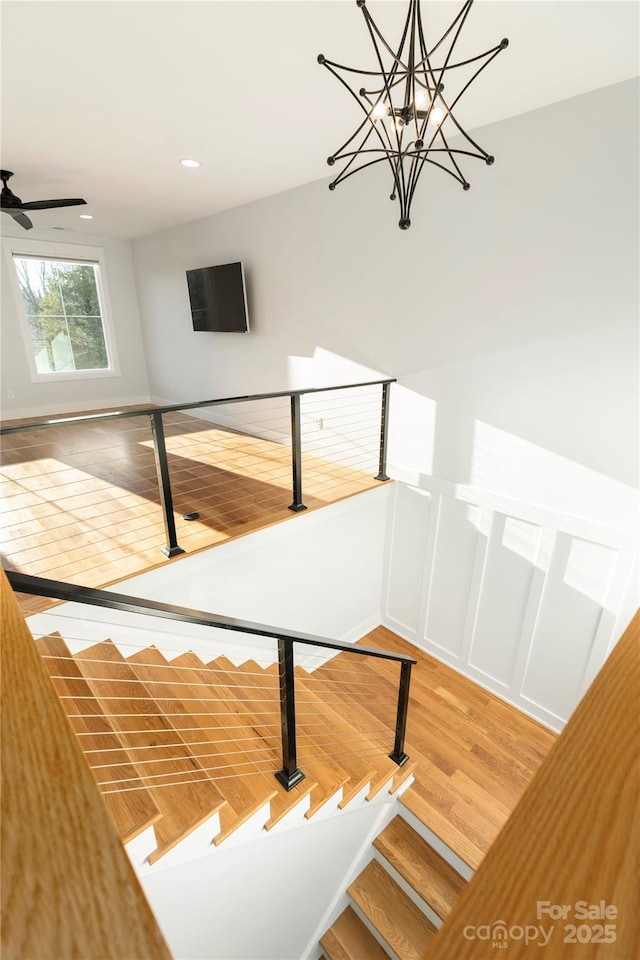 stairs with recessed lighting, wood finished floors, and a ceiling fan