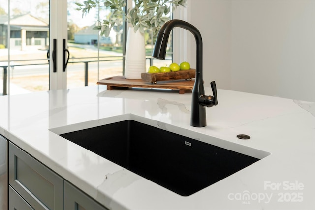 room details with light countertops, gray cabinets, and a sink