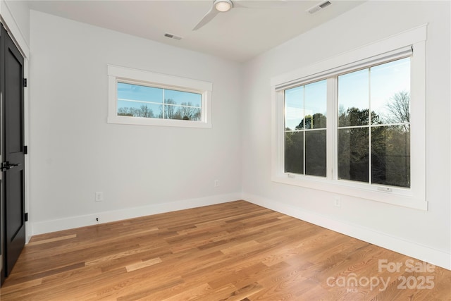 spare room featuring visible vents, plenty of natural light, and light wood-style floors