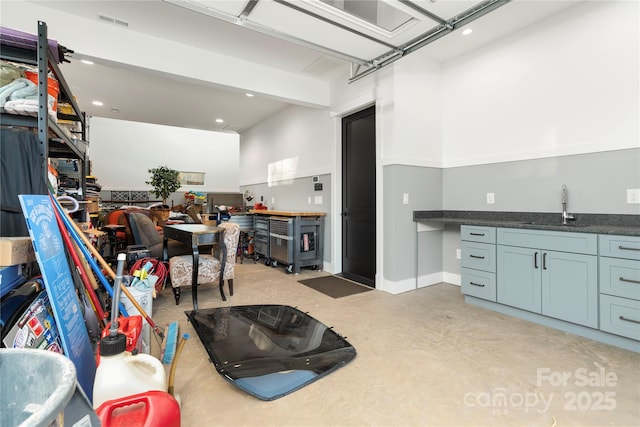 interior space with visible vents, a sink, dark countertops, open floor plan, and finished concrete floors