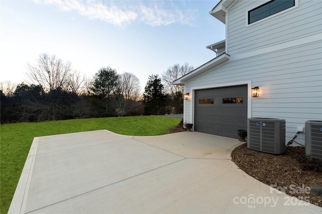 garage with central air condition unit and driveway