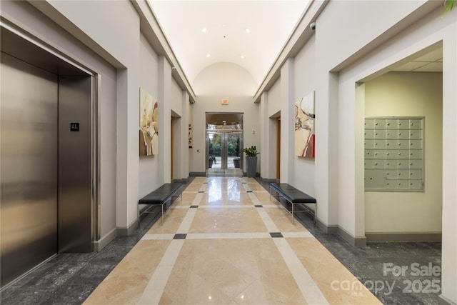 corridor featuring mail area, elevator, baseboards, and marble finish floor