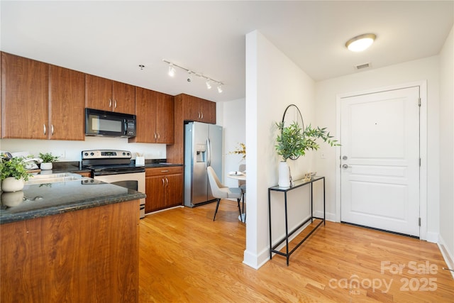 kitchen featuring visible vents, brown cabinets, a sink, appliances with stainless steel finishes, and light wood finished floors