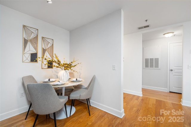 dining area featuring wood finished floors, visible vents, and baseboards