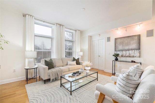 living room with light wood-type flooring, baseboards, visible vents, and track lighting