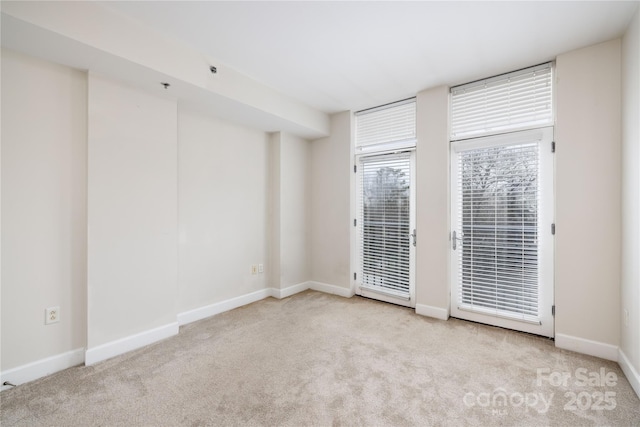 carpeted empty room featuring baseboards