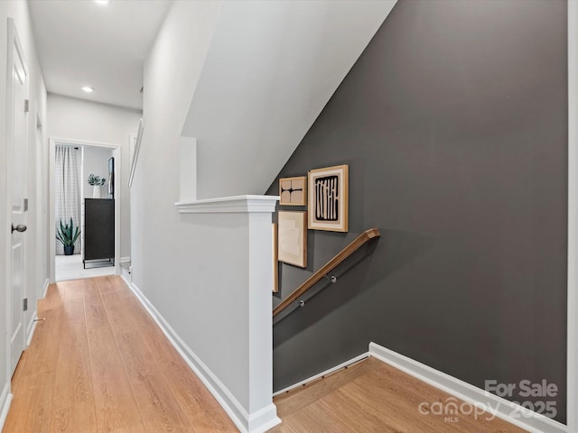 hall with recessed lighting, baseboards, an upstairs landing, and wood finished floors