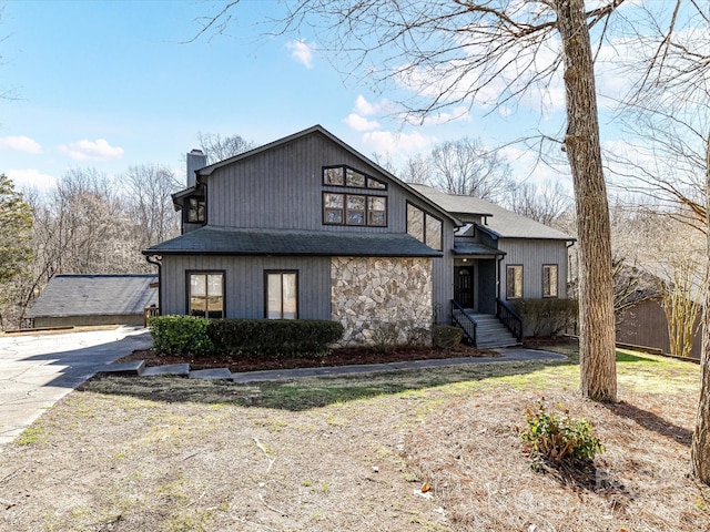 view of front of house featuring stone siding and a chimney