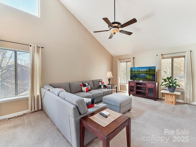 living area with a ceiling fan, light colored carpet, baseboards, and high vaulted ceiling