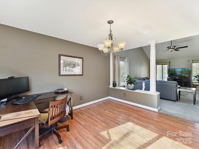 office with lofted ceiling, light wood finished floors, ceiling fan with notable chandelier, and ornate columns