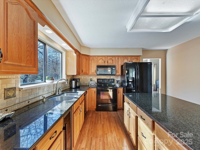 kitchen featuring beverage cooler, a sink, black appliances, light wood-style floors, and backsplash