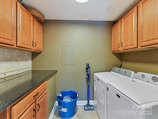 laundry area featuring electric panel, baseboards, cabinet space, and washing machine and dryer