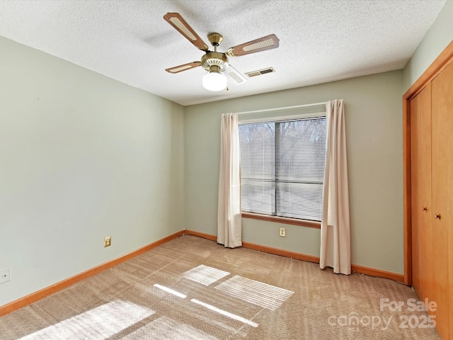 unfurnished bedroom with visible vents, baseboards, a textured ceiling, and carpet floors